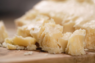 pieces of hard parmesan cheese on olive board