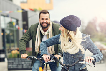 Fototapeta na wymiar Young couple riding bikes and having fun in the city