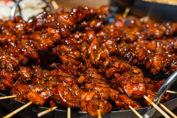 Appetizing roasted or barbecued marinated meat on skewers after hot grill at food festival