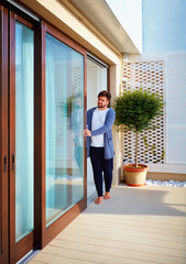man opening sliding glass doors on patio at home