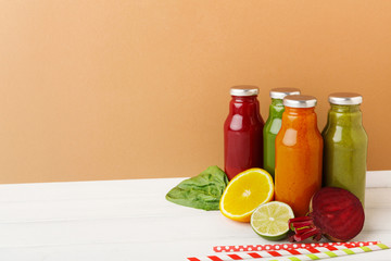 Assortment of detox smoothies in glass bottles on wall background.