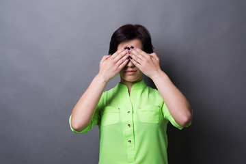 Scared woman covering eyes with hands, see no evil