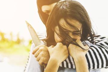 dangerous criminal person using a knife at Beautiful woman. thief threatening frightened woman. The...