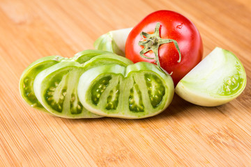 Fresh red and green tomatoes on a wood background