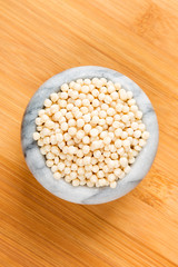 Toasted couscous grains on a wood background