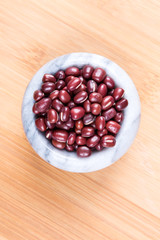 Red adzuki beans on a wood background