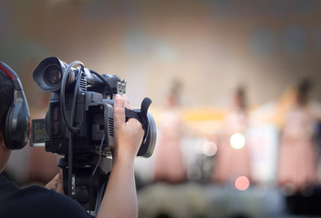 cameraman on duty with professional camcorder with blur background