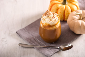 Pumpkin spice latte, hot coffee drink with pumpkins, whipped cream and spices