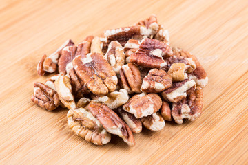 Organic shelled pecans on a wood background