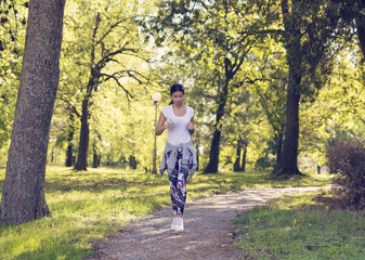Fototapeta premium A young girl jogging through the park