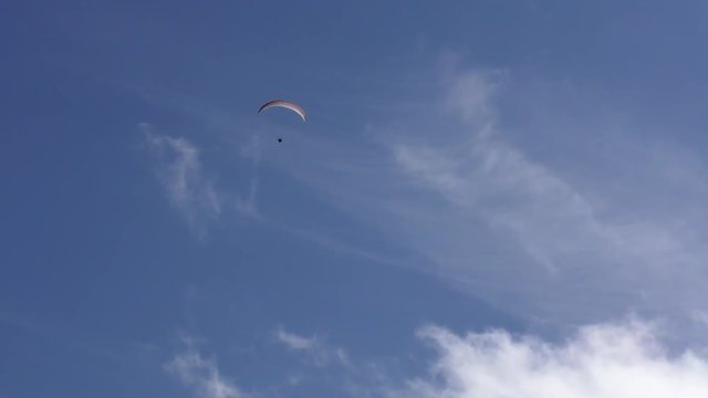 Gleitschirmflieger (Paraglider) vor blauem Himmel