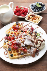 Sweet waffle with berries and ice cream on wooden table