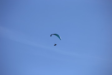 Gleitschirmflieger (Paraglider) vor blauem Himmel