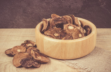 Dried forest mushrooms on a wooden table.