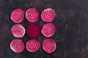 Arranged in pattern sliced beetroot on grunge background. Top view with copy space