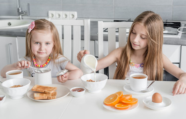 Two lovely sisters eating healthy breakfast