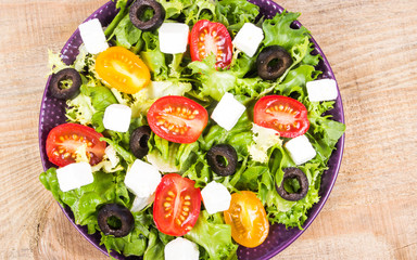 Greek salad with fresh vegetables, feta cheese and black olives.