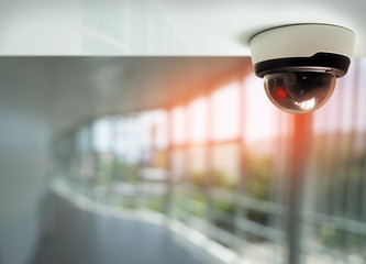security camera surveillance installed on ceiling - Powered by Adobe