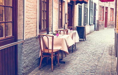 Cozy tables at small street cafe. Toned, closeup