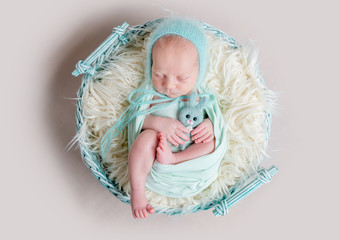 sweet newborn wrapped in a nappy sleeping on a round rug