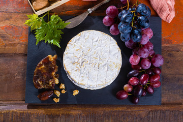 Famous French fresh soft cheese - camembert, delicious dessert with nuts and dried fruits