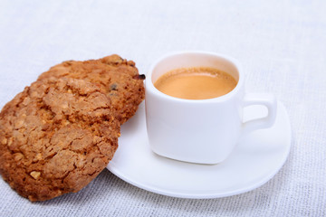 Classic espresso in white cup with cake on white background.