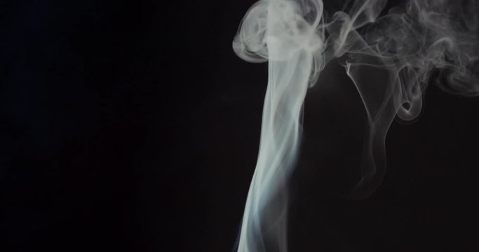 High contrast video of white smoke moving upwards isolated on black