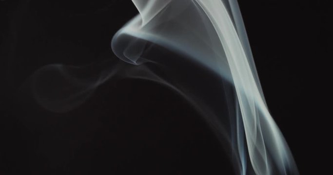 High contrast video of white smoke moving upwards isolated on black