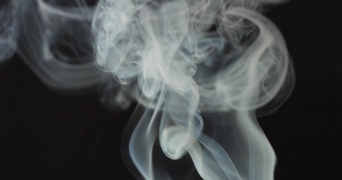 High contrast video of white smoke moving upwards isolated on black