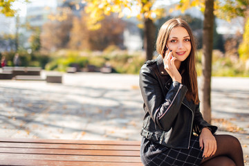 Young girl talk on the phone at park background