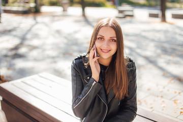 Young girl talk on the phone at park background