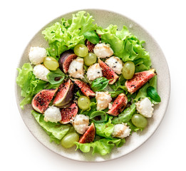 Salad with figs, mozzarella and grapes on a white wooden background.
