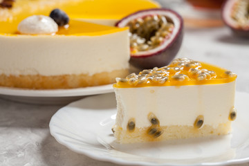 cheesecake with the passion fruit coulis on the black and wooden background