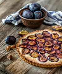 Homemade plum pie on the wooden background