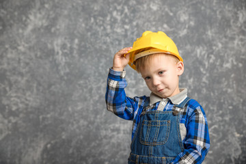 A boy holds onto a construction helmet and smiling