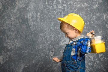 Boy in hard hat with construction line and box of tools