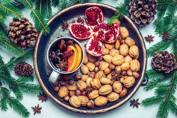 Mulled wine, nuts, fruits in tray top view.