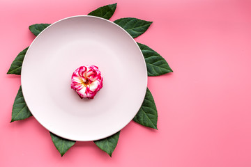 Plate, tropical leaf and fruit on pink background top view copyspace