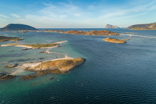 Aerial shot of archipelago with blue sea and sand beaches. In the background is bridge, islands Sommar&oslash;ya ( Sommaroya ) and H&aring;ja ( Haja ), Norway