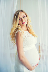 Pregnancy in a white lace dress. Waiting for the baby.