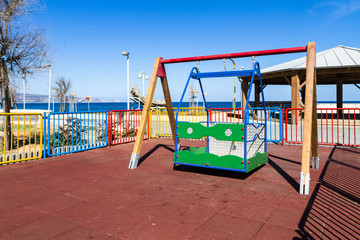 Children's safe wooden playground recreation area at seaside public park