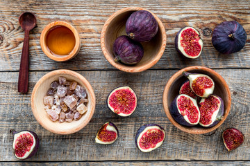 Make jam. Fresh blue figs in bowl, sugar and honey on wooden background top view