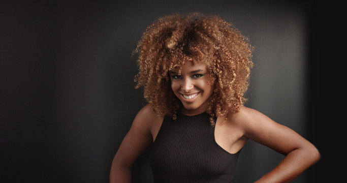 Pretty black girl with big hair posing video on black background