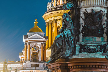 Fototapeta na wymiar Night view of the ancient statues of stucco and the dome of St. Isaac's Cathedral Petersburg.