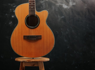 Fototapeta premium guitar on chair and black background.