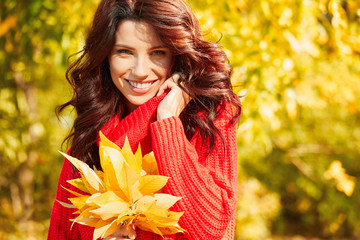 Portrait of beautiful brunette girl. Woman in red sweater. Autumn season