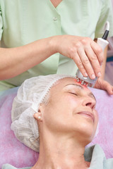 Rf skin tightening, adult woman. Hand of cosmetician working.