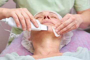 Ultrasonic face cleaning tool. Cosmetology procedure close up.