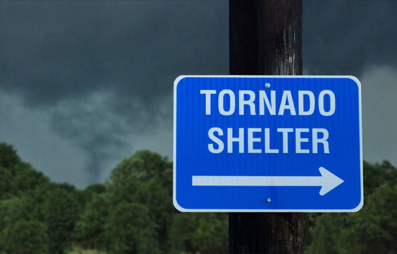 Tornado shelter sign with a small funnel cloud on background - concept for immediate danger in severe weather and seeking for shelter