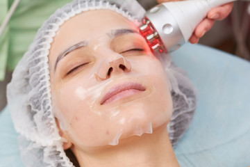 Facial hydrogel mask close up. Woman undergoing skin treatment.